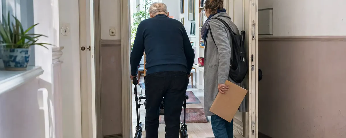 Krankenhausentlassung Checkliste - älterer Mann mit Rollator kehrt mit seiner Tochter in eine Berliner Wohnung zurück - Amor Pflegedienst