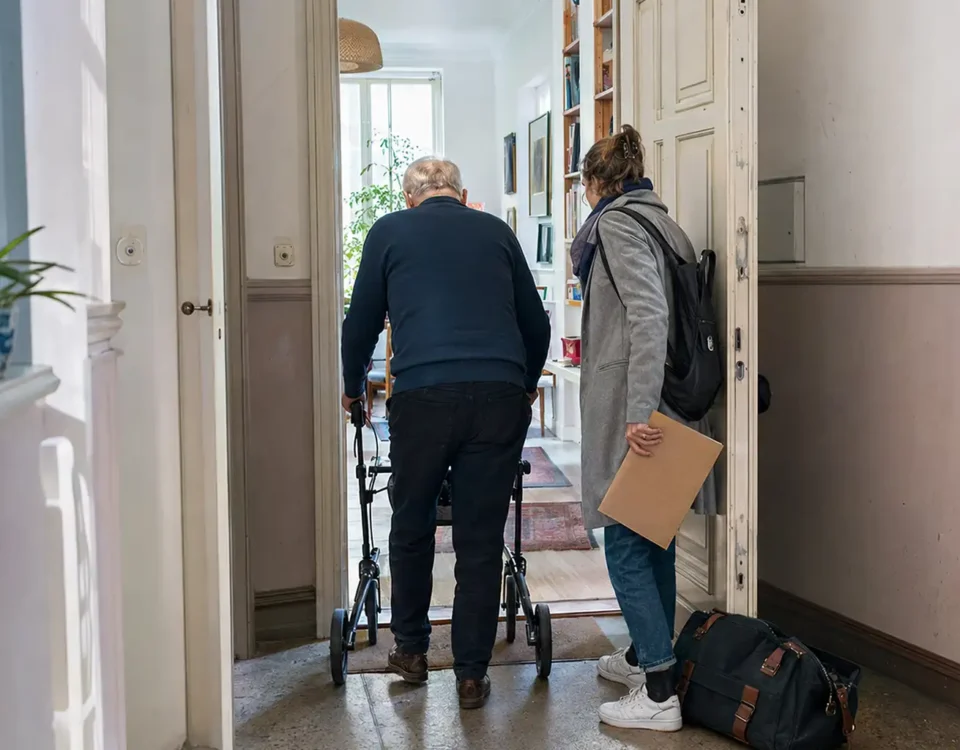 Krankenhausentlassung Checkliste - älterer Mann mit Rollator kehrt mit seiner Tochter in eine Berliner Wohnung zurück - Amor Pflegedienst